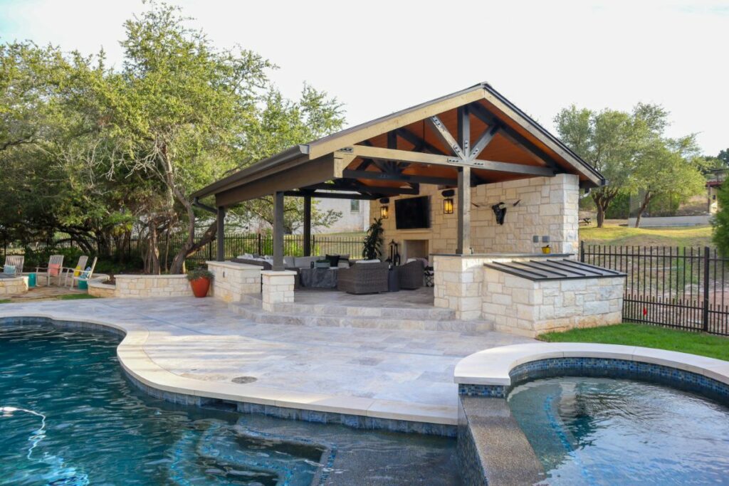 An Outdoor Living Area with a Large Covered Seating Area, a Firepit, a Pool, and a Hot Tub